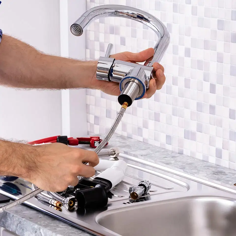 Faucet Installations and Repairs in Surrey, Vancouver, and Surrounding area. Plumber-Fixing-Kitchen-Faucet